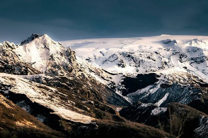 Verschneite Gipfel unter blassem Himmel